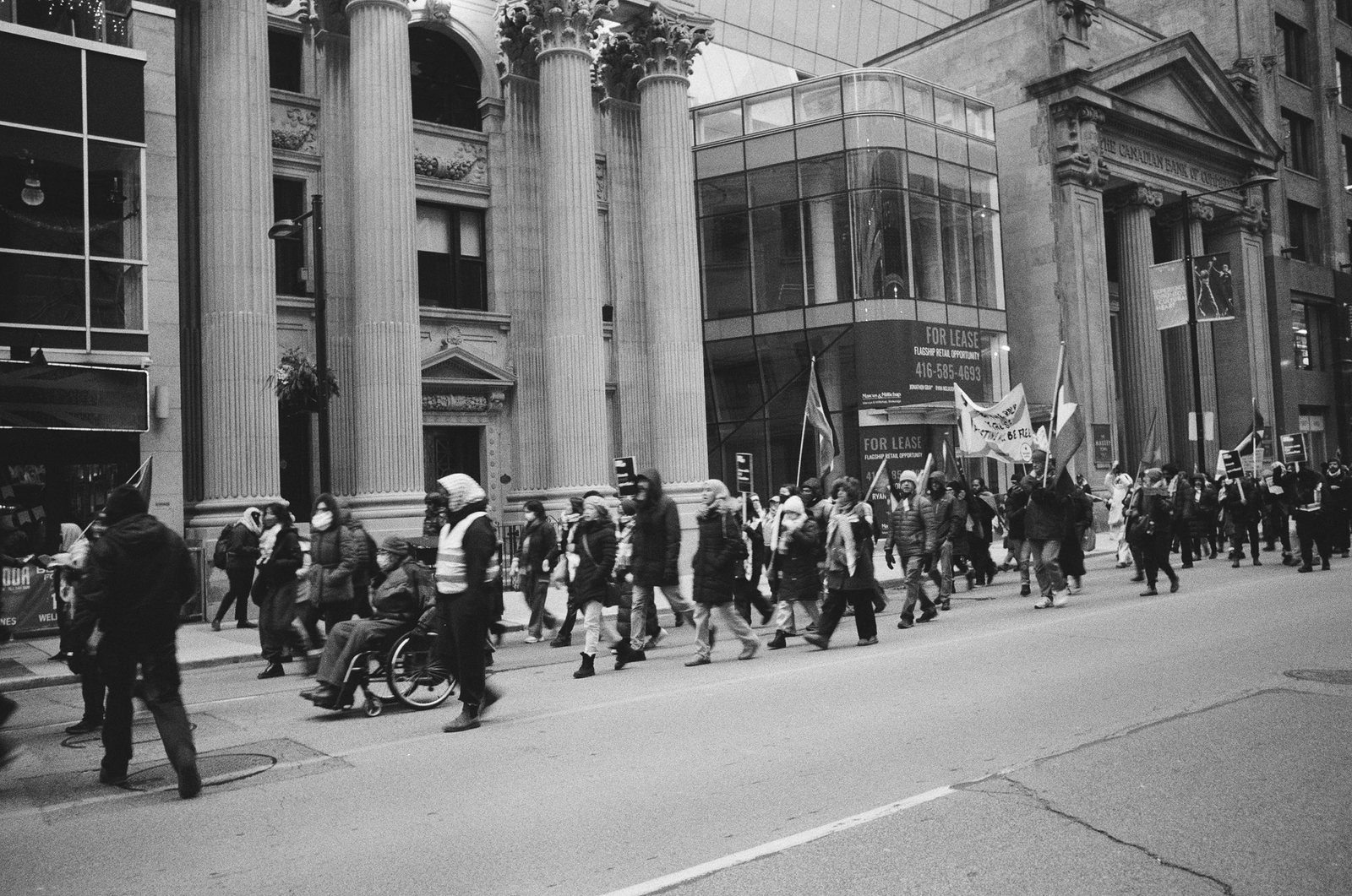 A street march passing historic stone buildings