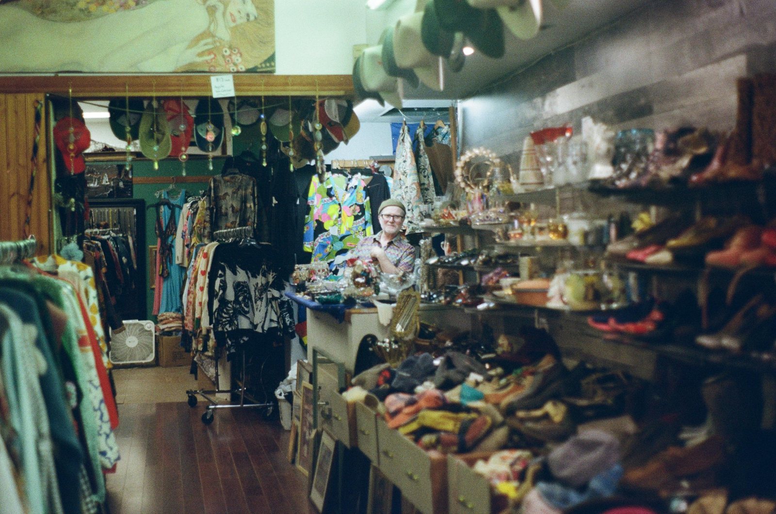 A shopkeeper standing among shelves of vintage objects