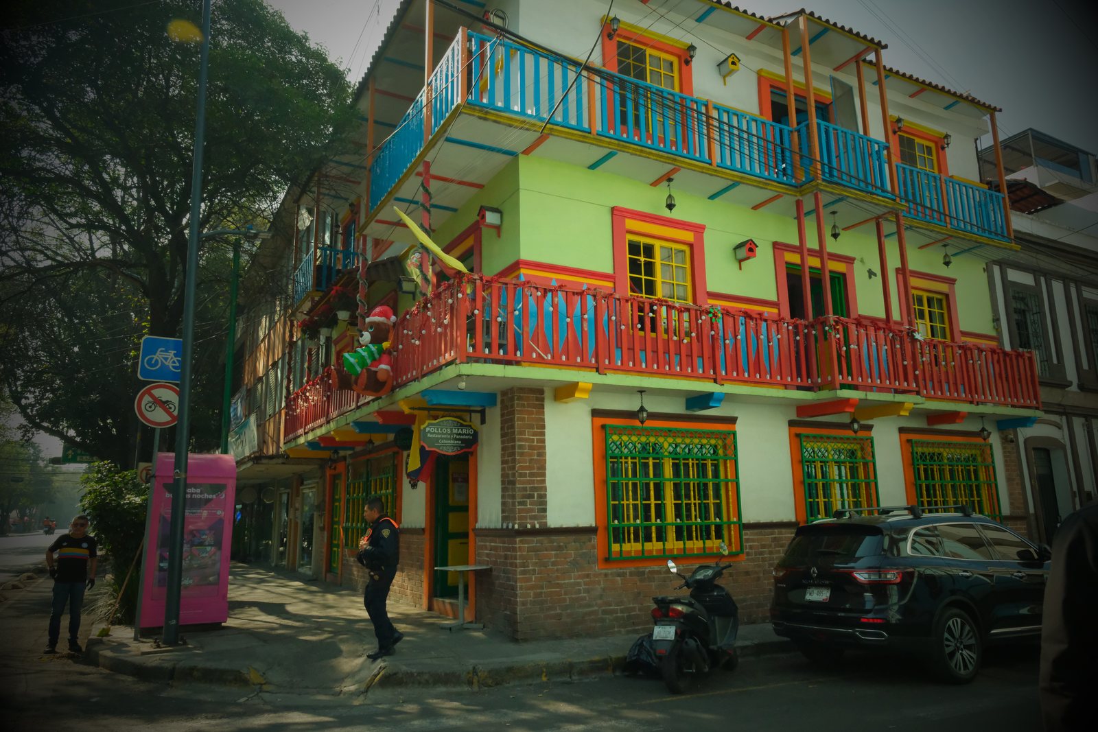 A vivid green building with red and blue balconies